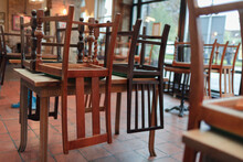 Wooden Chairs Upside Down On Tables In Empty Restaurant