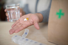 Close Up Woman Holding Prescription Medication And Glass Of Water
