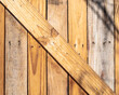 Wooden Crossbeam Diagonal Background Pattern Template featureing a detail of a portion of a fence gate door constructed from 2x4s and pallet wood.