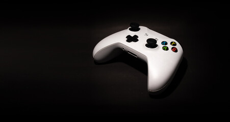 Video game controller on black background and space for text.