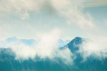 Wall Mural - Mountain peaks with clouds in foggy morning. Beautiful nature background. Vintage filter