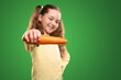 Smiling girl showing fresh carrot