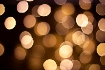 Bokeh. Golden defocused lights on a dark brown background. Concept for design