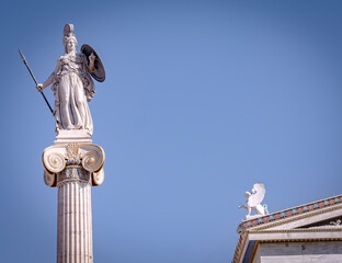 Athena white marble statue and and small sphinx statuette under blue sky with space for your text, Athens Greece