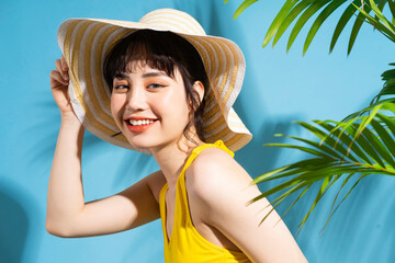 Wall Mural - Beautiful Asian woman wearing yellow jumpsuit on blue background and, summer concept