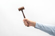 Judges gavel in mens hand on white background. Wooden hammer for auction.