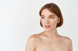 © Cookie Studio - Beauty face. Young beautiful woman with naked shoulders, natural smooth and healthy facial skin, looking away at empty space logo. Girl have perfect face without blemishes, skincare concept