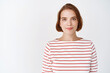 © Cookie Studio - Beauty. Portrait of young confident woman with natural light facial skin, smile tenderly at camera, standing in striped blouse against white background