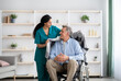 © Prostock-studio - Young nurse covering disabled elderly man in wheelchair with warm plaid at retirement home