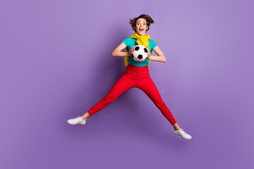 Poster - Full length photo of lady jump hold ball open mouth wear t-shirt trousers sneakers isolated violet color background