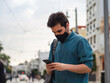 © David Martínez - Hombre joven usando su movil con mascarilla