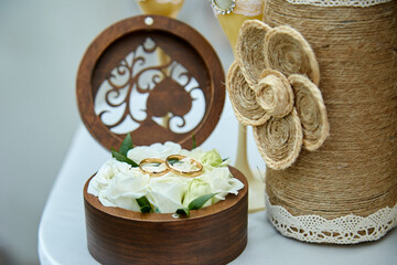 Wedding rings lie on a beautiful, decorative hand made rustic box with plants inside,