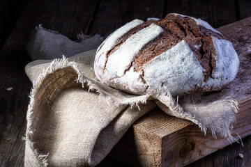 Freshly baked rye round bread from alternative flour on the kitchen Board. Homemade cake. The fermentation process. Slow baking.