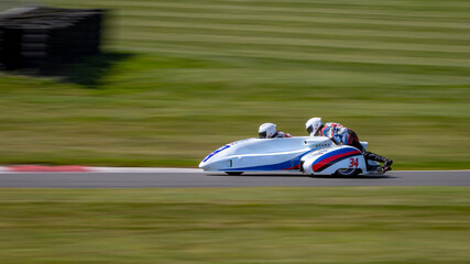 A panning shot of a racing sidecar as it corners on a track.