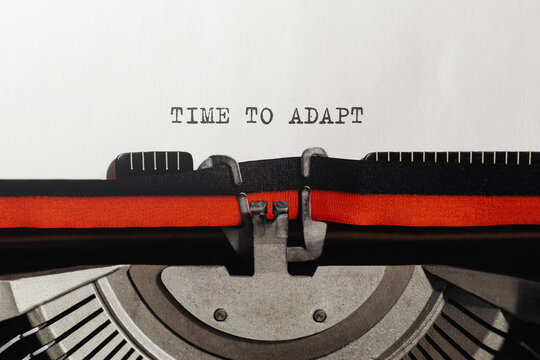 Text TIME TO ADAPT typed on retro typewriter