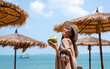 © Farknot Architect - Portrait image of a beautiful asian woman holding a fresh coconut and enjoying on the beach