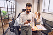 © Roman - Young trader in elegant business wear looking at phone while working at the office