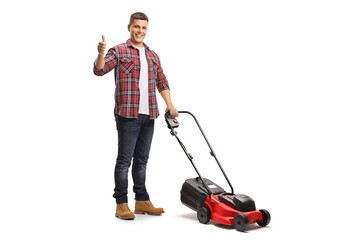 Wall Mural - Full length portrait of a young man with a lawnmower machine showing thumbs up