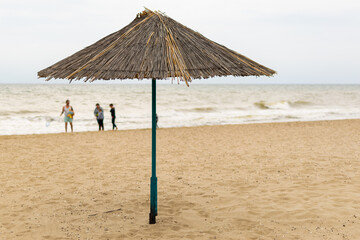 Wall Mural - Beach umbrella made of straw by the sea.