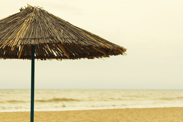 Wall Mural - Beach umbrella made of straw by the sea.