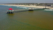 Aerial Panning: Pier On Red Tide In Sea During Sunny Day