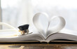 An open book. The pages are folded in the shape of a heart. A stethoscope pressed against the pages. Concept-education, the pulse of literature.
