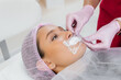 © Andrii - Moisturizing the lips during a cosmetic procedure for a young girl. Cosmetology