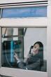 © Joseph Table - Young dark-haired woman calling from an urban phone booth. Vintage Young dark haired woman calling from an urban phone booth while looking seriously. Vintage. Businesswoman