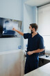 © Alberto Ortega/ADDICTIVE STOCK - Anonymous male vet in respiratory mask and uniform explaining anatomy of mammal animal while touching screen with X ray illustration in clinic