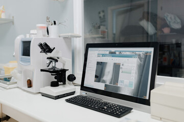 From above of microscope near computer with open program on screen in vet laboratory
