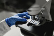 © Carlos Pintau/ADDICTIVE STOCK - Crop anonymous scientist in protective gloves putting sample under microscope lens while conducting chemical research in laboratory