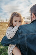 © Israel De Lago/ADDICTIVE STOCK - Side view of happy father cuddling cute little daughter while standing in countryside
