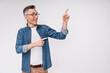 Good-looking mature white man in casual outfit pointing at copy space isolated over white background
