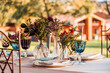 © Javier Bravo/ADDICTIVE STOCK - Close-up of served festive table with crystal glasses cutlery napkin on plate near bunch of fresh flowers for wedding and menu card