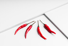 High Angle Composition Of Hot Red Chili Peppers Arranged Plate Against White Geometric Surface Background