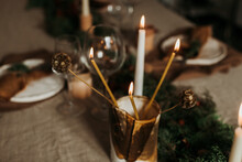 Composition With Flaming Candles Placed In Golden Candleholder On Table Decorated For Xmas Holiday