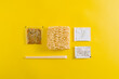 © Jose Lax/ADDICTIVE STOCK - Top view layout of uncooked noodles with spices ingredients and sticks in plastic packages on yellow background