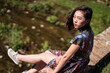 © Juan Alberto Ruiz/ADDICTIVE STOCK - Side view of Asian female in dress sitting on old Daping Red Bridge and enjoying summer vacation in Taiwan