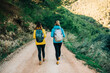 © Luis Tenza/ADDICTIVE STOCK - Female hikers in warm clothes walking along sandy road in highlands while enjoying nature and checking time during trekking
