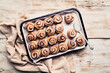 © Luis Garcia/ADDICTIVE STOCK - Top view of many glazed cinnamon rolls placed in rows on baking tray on wooden table