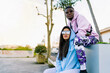 © Luis Manuel Munoz/ADDICTIVE STOCK - Young black man in trendy wear sitting close to female partner in contemporary sunglasses while looking away in town