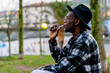 © Luis Manuel Munoz/ADDICTIVE STOCK - Serious African American male wearing stylish checkered shirt sunglasses and hat smoking cigarette