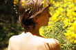 © Marianna Jaszczuk/ADDICTIVE STOCK - Back view of calm adult naked female resting in garden near blooming tree with yellow flowers on sunny day