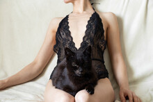 Girl In Black Lace Lingerie With A Black Cat Sits On A White Sofa