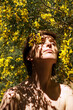© Marianna Jaszczuk/ADDICTIVE STOCK - Low angle of calm adult naked female with closed eyes resting in garden near blooming tree with yellow flowers on sunny day