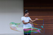 © Pablo Adrada/ADDICTIVE STOCK - Cheerful young African American female teenager with dark hair in white t shirt playing with big colorful soap bubbles and having fun standing on street near wooden wall