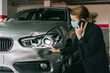 © Older Garcia/ADDICTIVE STOCK - Unrecognizable concentrated female insurance officer in formal suit and protective mask talking on mobile phone while inspecting car damages and filling out claim after accident