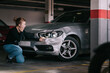 © Older Garcia/ADDICTIVE STOCK - side view of upset young lady in casual clothes sitting on knees and touching damaged car headlights after accident in parking space