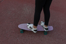 From Above Of Crop Faceless Female Teenager In Trendy Sneakers On Penny Board During Training On Sports Ground