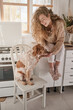 © Philippe Degroote/ADDICTIVE STOCK - Charming female sitting on counter with cute Setter dog during breakfast at home